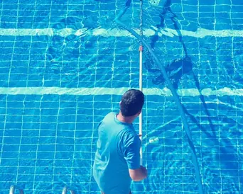 pool technician vacuuming tiled pool floor